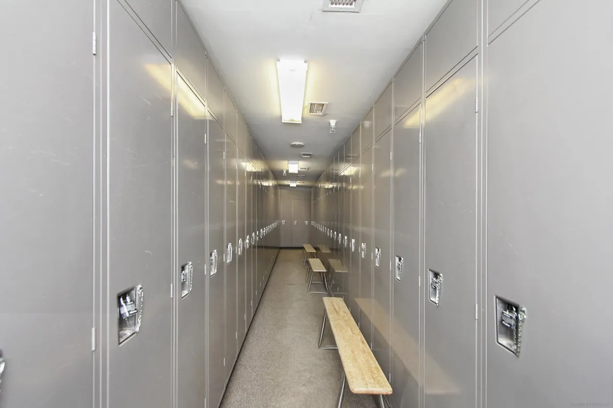 A functional interior storage area equipped with metal lockers and benches, designed for ski and bike storage. The space is well-lit and organized, providing a secure place for guests to change gear or store equipment before heading out for adventure.